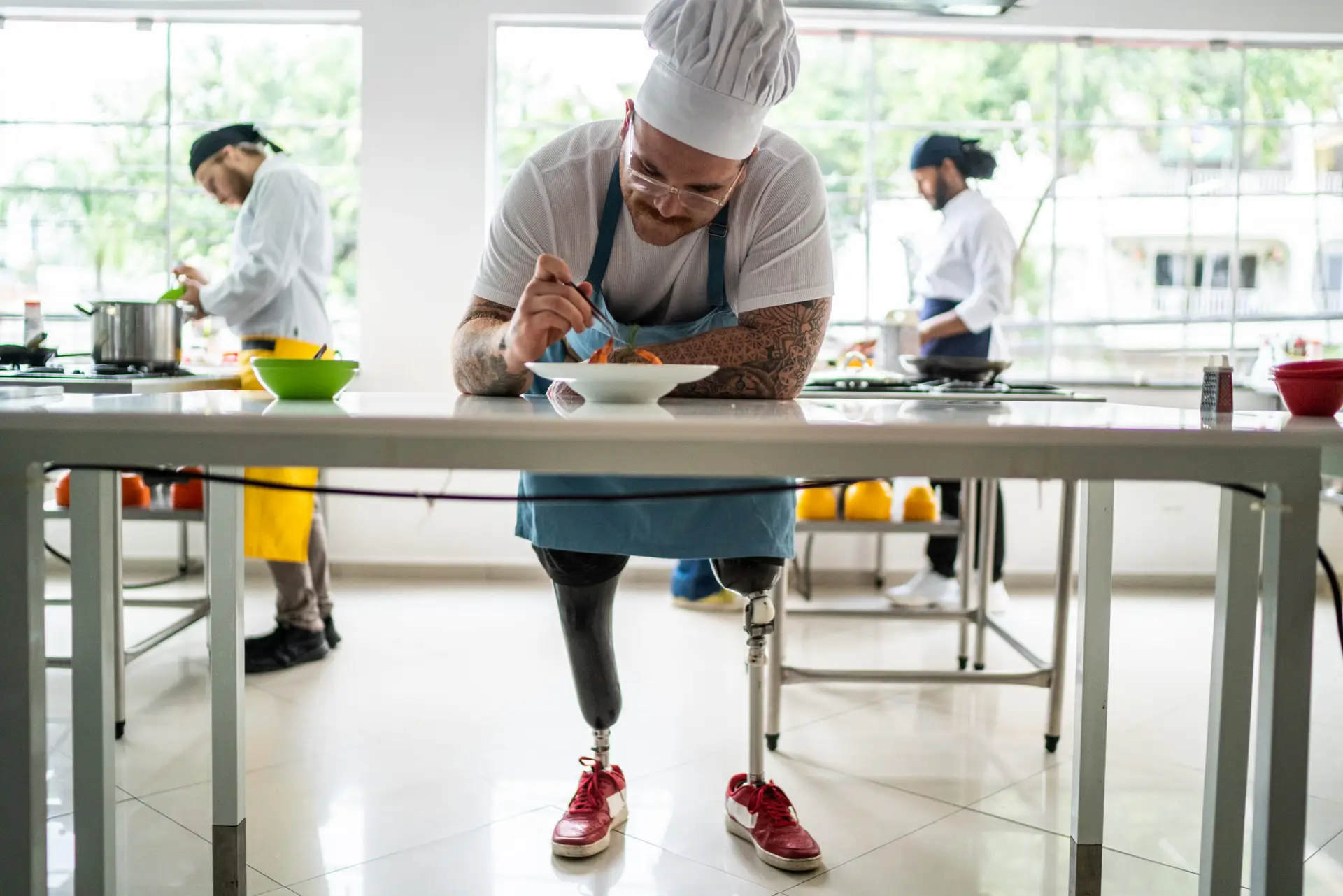 Disabled chef arranging details in a pasta dish